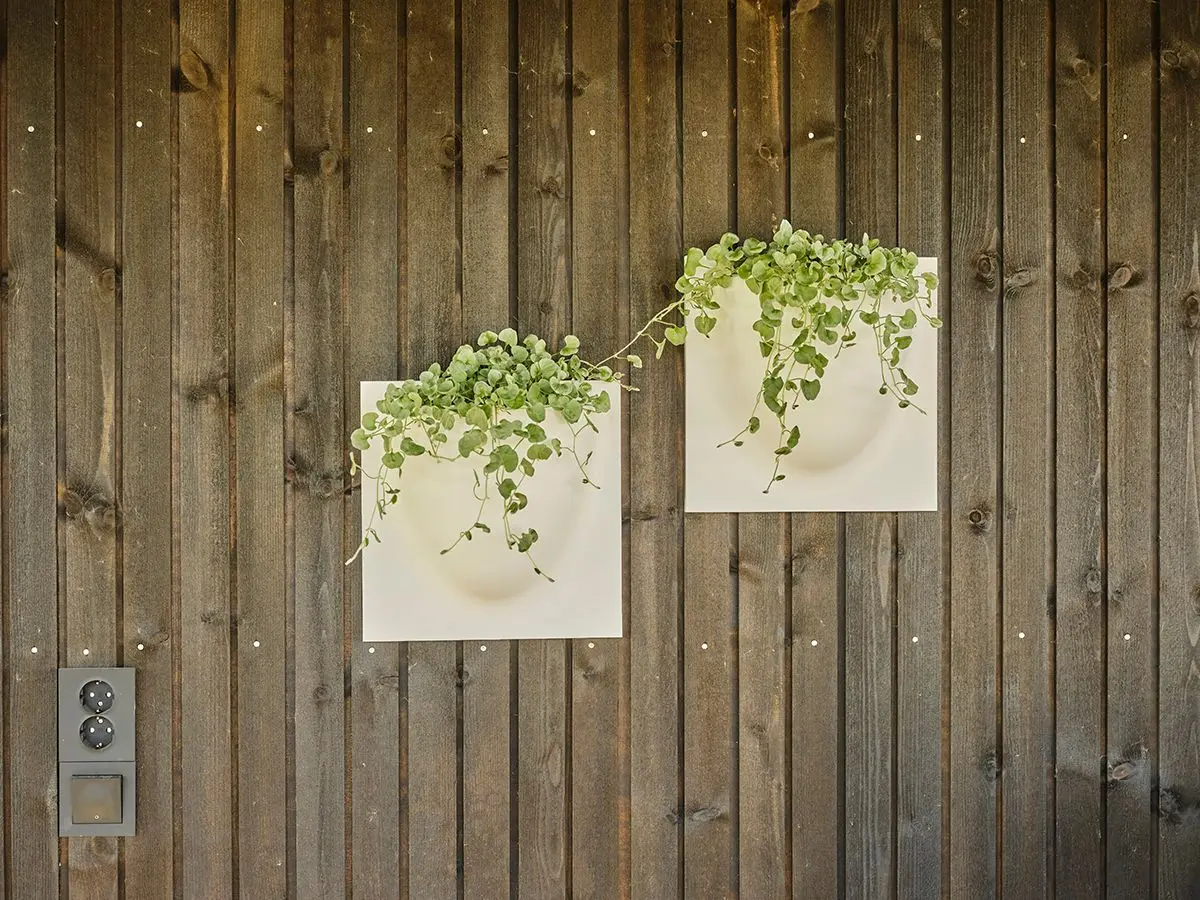 kledning i dobbelfals rettkant med fuge og to blomserpotter hengende på veggen