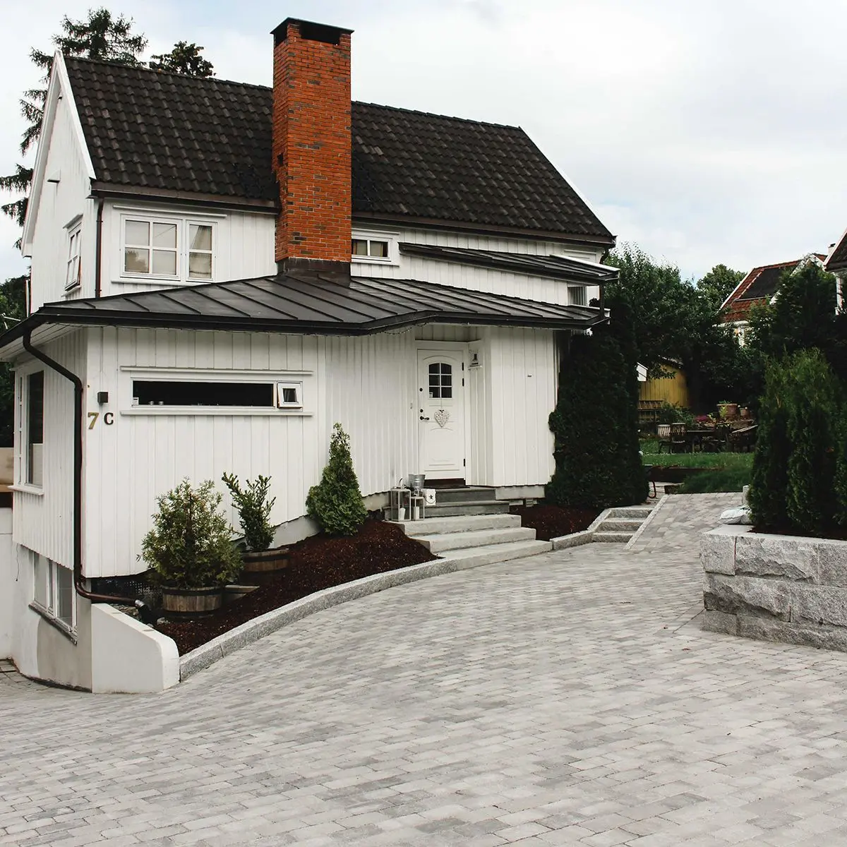 Hvitt hus og gårdsplass med belegningsstein Rådhus gråmix fra Aaltvedt